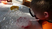 Kind experimentiert mit Seifenblasen