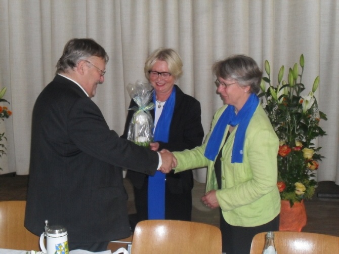 An Pfarrer Stadler wird ein Geschenk überreicht und Gratuliert