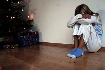 Mädchen enttäuscht neben dem Christbaum