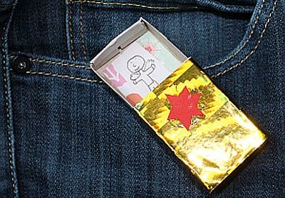 Engel in einer Streichholzschachtel liegt auf einer Jeans