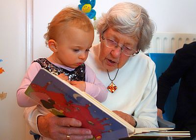 Oma liest ihrer Enkelin aus einem Kinderbuch vor