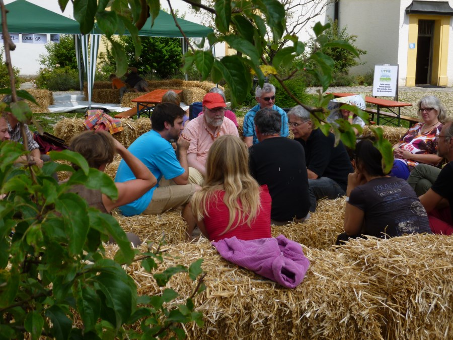 Gäste auf Strohballen beim Festival der Utopie 2014
