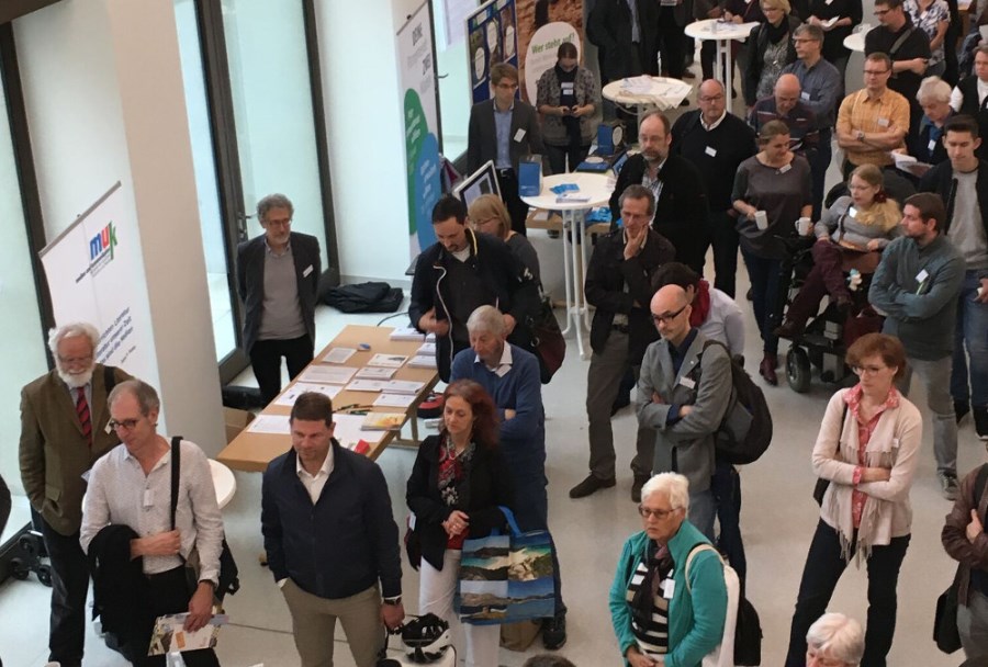 Teilnehmer verfolgen in der Eingangshalle die Einführung
