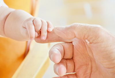 Babyhand hält Finger eines Erwachsenen