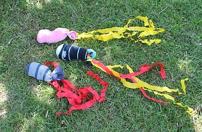 Pfingstblitze: mit Stoffresten gefüllte Socken, daran befestigt sind gelbe und rote Papierstreifen